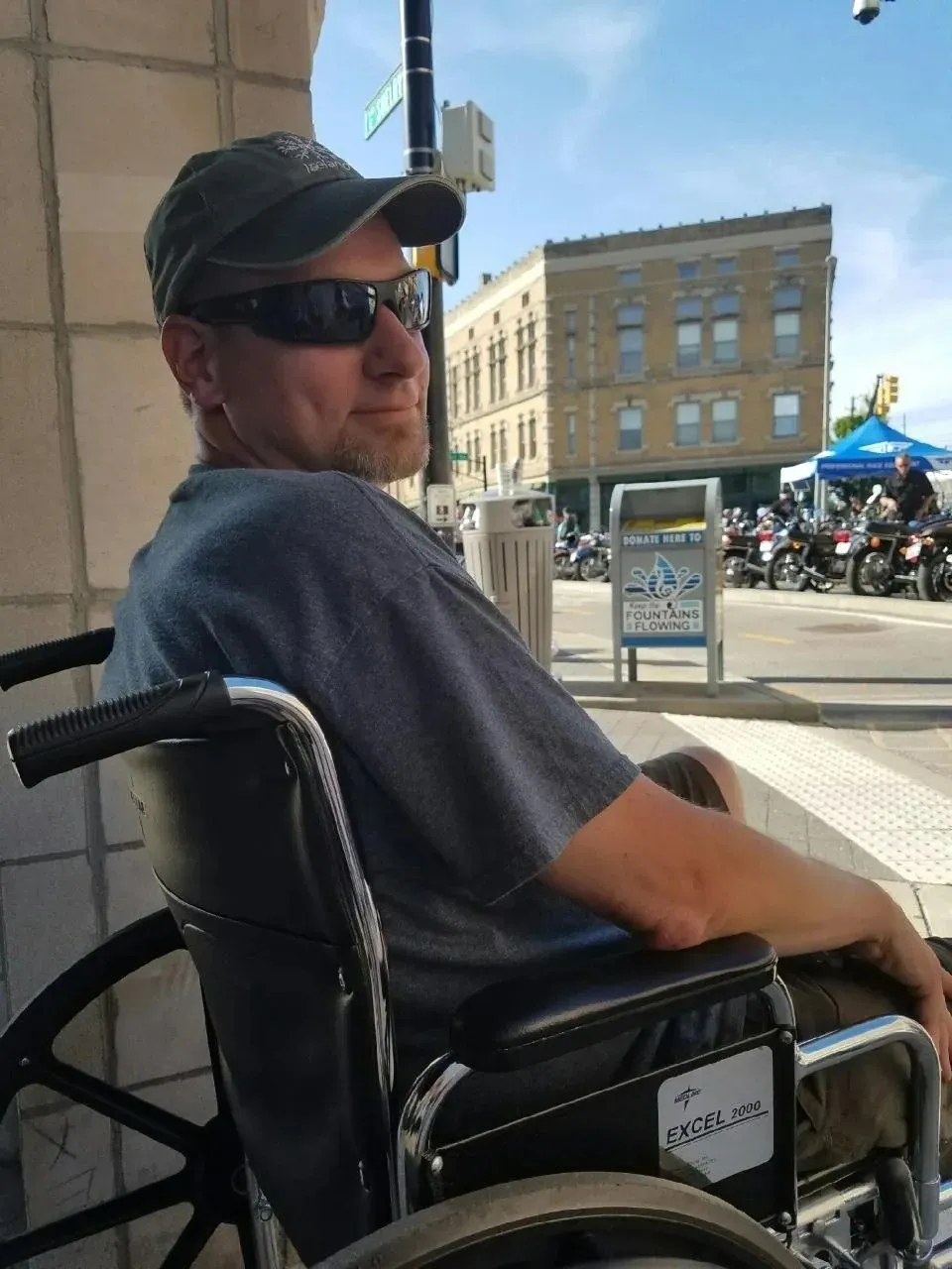 A man in a wheelchair with sunglasses on.